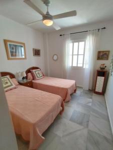 a bedroom with two beds and a ceiling fan at Apartamento Plaza Nueva del Morche in Morche