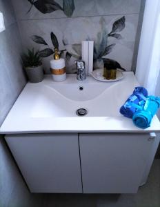 a white bathroom sink with blue items on it at Blue Lotus Studio in Agia Marina Nea Kydonias