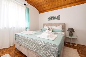 a bedroom with a bed with towels on it at Tinel Apartment Sukosan in Sukošan