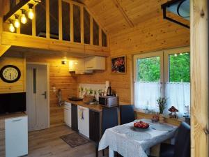 a kitchen with a table in a cabin at Domki Na Wzgórzu - domek nr 1 in Mrągowo