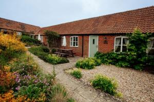 ein Garten vor einem Haus mit Blumen in der Unterkunft Thatchers Cottage - Rudge Farm Cottages in Bridport