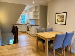 a kitchen and dining room with a wooden table and chairs at Haus-Seemoewe in Süddorf