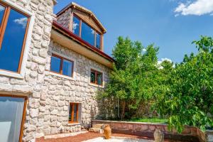 a stone house with a tree in front of it at Nissa Cave in Göreme