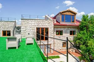 a stone house with a green lawn at Nissa Cave in Göreme