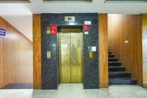 a elevator with a gold door in a building at FabHotel Prime Mahalaya Residency in Chennai