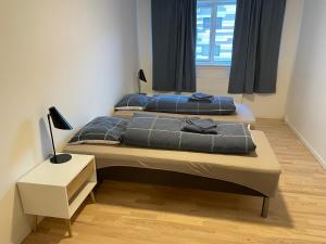 two beds in a small room with a window at inuit Bolig & Apartments in Nuuk