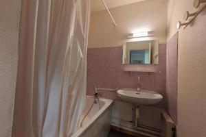 a bathroom with a sink and a shower curtain at Au centre de la station 6 personnes in La Féclaz