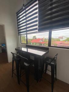 a table and chairs in a room with a window at TBJ HOMESTAy in Wakaf Baharu