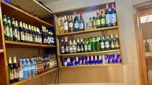 a shelf filled with lots of bottles of alcohol at Safari Homes in Kampala