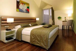 a bedroom with a large bed and a desk at Hotel Korkyra in Vela Luka