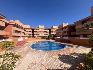 a swimming pool in a courtyard of a building at OBSIDIAN Aguamarina in Puertito de Güímar