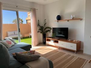 a living room with a couch and a flat screen tv at OBSIDIAN Aguamarina in Puertito de Güímar