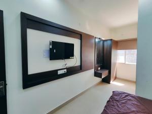 a bedroom with a flat screen tv on the wall at Hotel Heritage Palace - Bhuj in Bhuj
