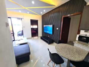a living room with a table and a television at Dair Ghbar Gate Apartments in Amman
