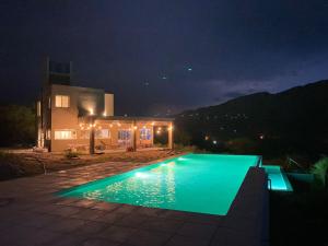 a swimming pool in front of a house at night at La Deseada in Quines