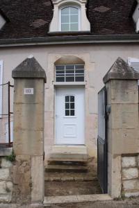 a house with a white door and a gate at Le relais in Prémeaux