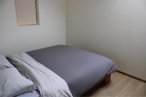 a bed with white sheets and pillows in a room at Le relais in Prémeaux