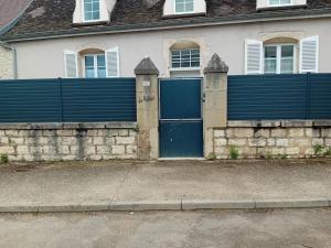 a house with a blue fence and a blue door at Le relais in Prémeaux