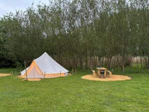 a tent and a grill in a field with trees at Birch Bell Tent in Droitwich
