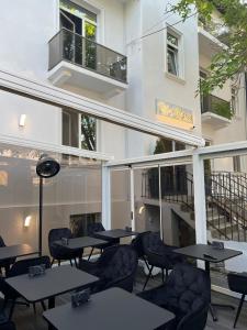 a patio with tables and chairs in front of a building at La Vila Maria in Bucharest