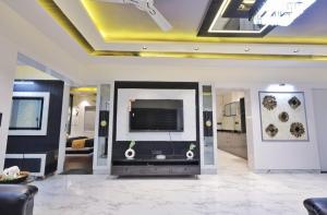 a living room with a flat screen tv on a wall at Classic Premium luxurious 3bhk fully furnished apartment in koregaon park in Pune