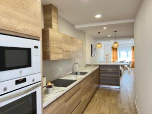 a kitchen with a sink and a microwave at Arroyada 14 in Sonseca