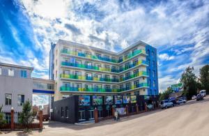 a white building with colorful windows on a street at Lime Hotel in Khabarovsk