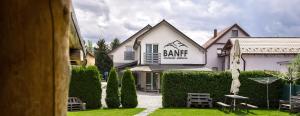 a white building with a sign on the front of it at Apartmány Banff in Bešeňová