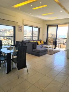 a living room with a couch and a table at Dair Ghbar Gate Apartments in Amman