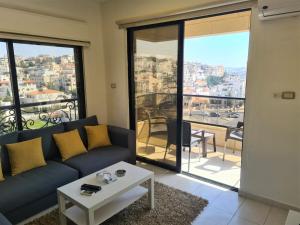 a living room with a couch and a table at Dair Ghbar Gate Apartments in Amman