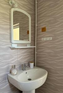 a bathroom with a white sink and a mirror at Lovin's Rooms in Tuzla +10 photos