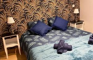 a bedroom with a bed with blue pillows and a wall at Maison charmante aux Riceys avec cour extérieure in Les Riceys