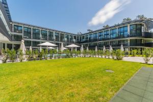 un prato vuoto davanti a un edificio con ombrelloni di Apartament Prywatny w Stegnie na ulicy Brzozowej 6 na I piętrze a Stegna