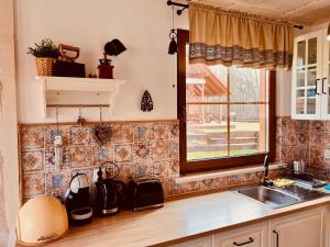 a kitchen with a sink and a window at Kaszubski Dom Ostoja Bukowo in Borowy Młyn