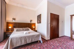 ein Schlafzimmer mit einem großen Bett mit einem hölzernen Kopfteil in der Unterkunft Medica Hotel Krojanty Bory Tucholskie in Chojnice