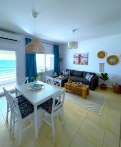 a living room with a white table and chairs at Kima Sea Apartment in Nikiti