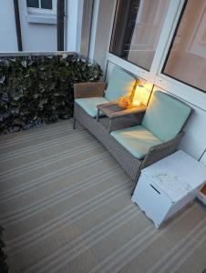a porch with two chairs and a table and a lamp at ALLROOM Modernes Apartment in Unterschleißheim Nur 20 Minuten nach München in Unterschleißheim