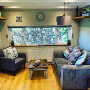 a living room with a couch and a coffee table at The Cabin at Bragdy in Pwllheli