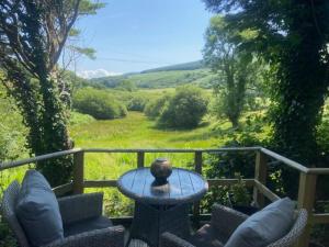 a table on a balcony with a view of a field at The Cabin at Bragdy in Pwllheli