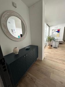 a living room with a black dresser and a mirror at BOUTIQUE HOME LIGNANO in Lignano Sabbiadoro