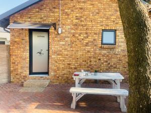 a table and a bench in front of a brick building at Rollers Rest Guesthouse in Boksburg