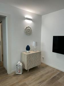 a living room with a table with a lamp and a tv at BOUTIQUE HOME LIGNANO in Lignano Sabbiadoro