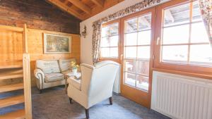 a living room with two chairs and a window at Bichlhof Appartements, mit Wellness im Hotel Charlotte in Seefeld in Tirol +10 photos