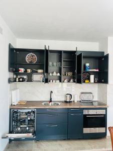 Una cocina con gabinetes azules y una encimera. en Villa Holiday, en Bihać