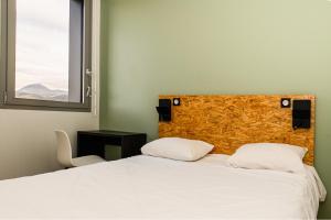 Een bed of bedden in een kamer bij Auberge de jeunesse HI Clermont-Ferrand