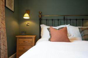 a bedroom with a white bed and a night stand at Plato's in Kirkby Lonsdale