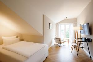a hotel room with a bed and a desk at Vju Hotel Rügen in Göhren