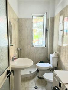 a white bathroom with a toilet and a sink at Ground floor Studio in Golem Next to Hotel Flower self check in 100m to beach in Golem +18 photos