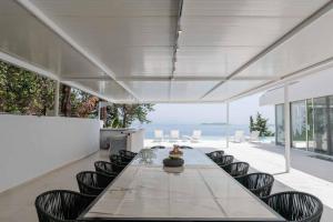 a long table and chairs in a room with a view at Villa Lazareto in Kontokali