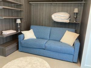 a blue couch with pillows in a living room at Studio Boniche 1 bedroom 1 slaapkamer in Zeebrugge +1 photo